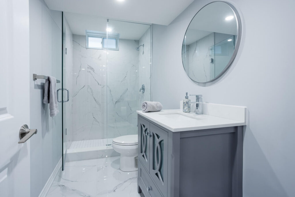 two fold shower glass door with white toilet seat and vanity with counter top
