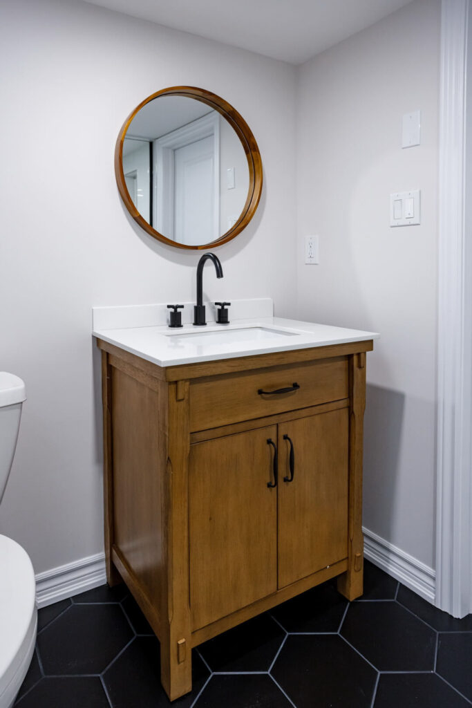 wooden single vintage vanity with with white countertop and black faucets