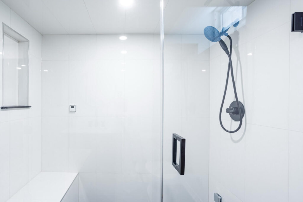 white square tiled shower wall with glass door