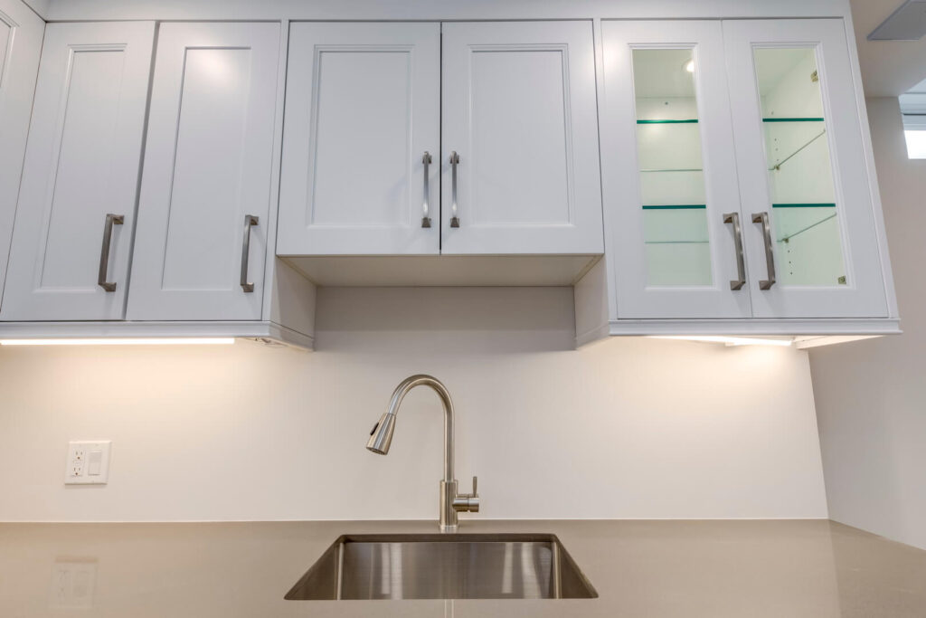 kitchen sink with white cabinets and rose gold countertop