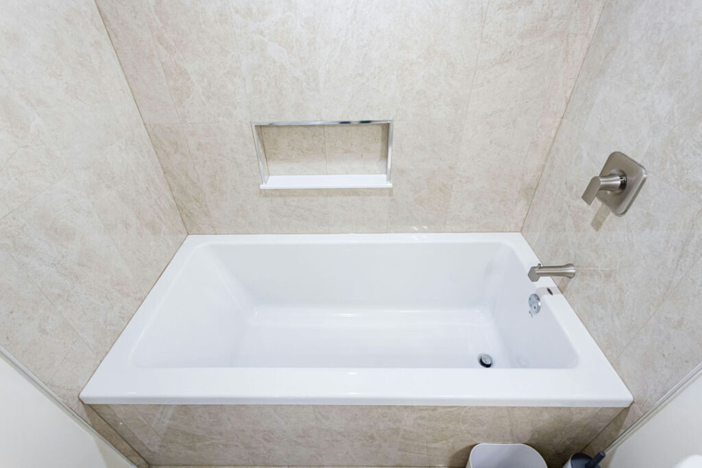 floor mounted bath tub with marble tiled walls