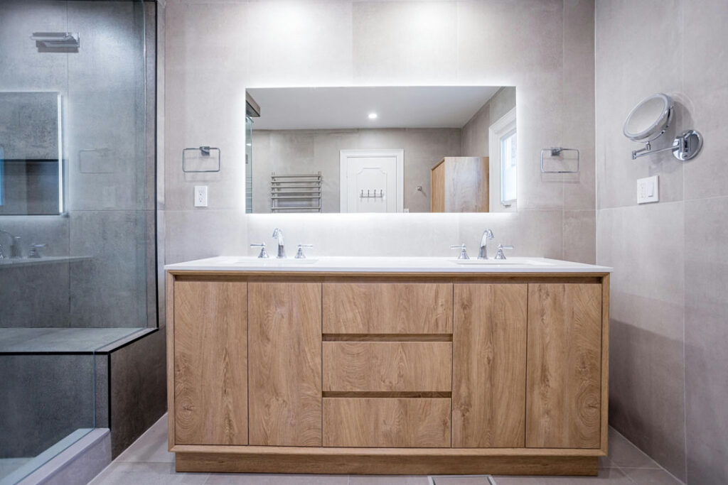 large vanity in bathroom with two basin sinks and countertop with large mirror and led lights