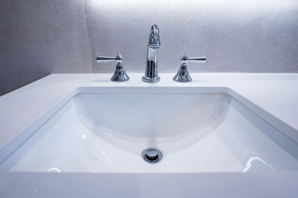 ceramic glossy countertop with basin sink and faucets