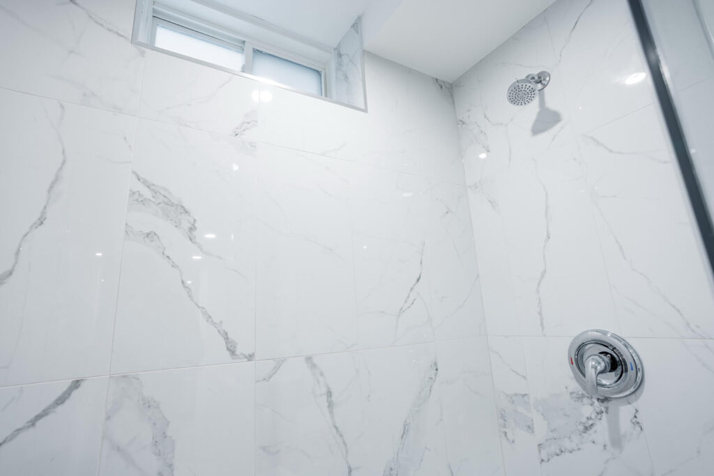 bathroom shower unit with marble tiled wall with window for ventilation