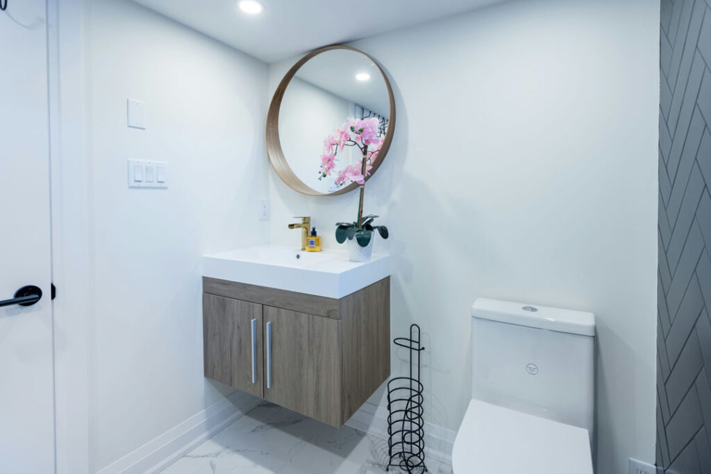floating modern wooden vanity with round mirror and golden faucets