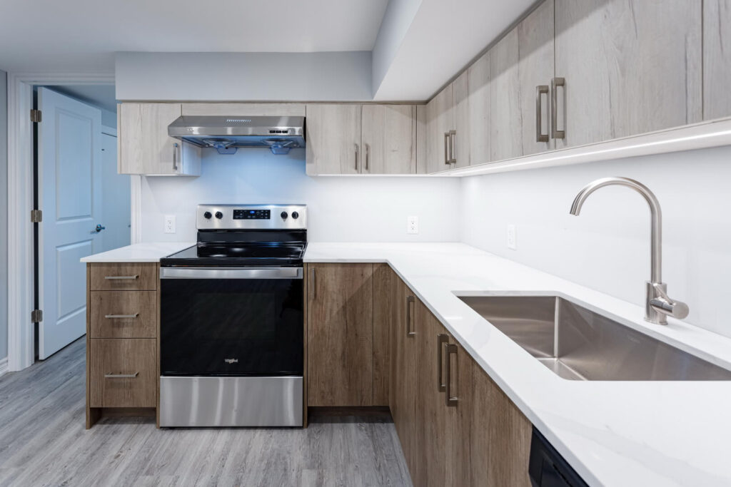 brown kitchen cabinets with white tiled wall and countertop
