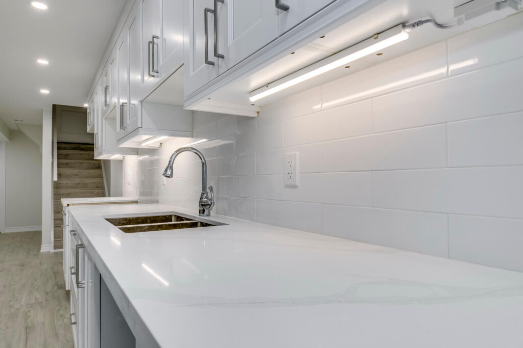 white tiled kitchen wall with countertop and sink space