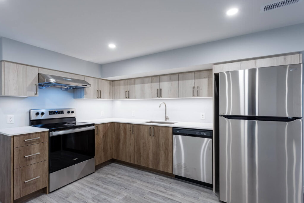 modern basement kitchen renovation with wooden storage cabinets and white countertop