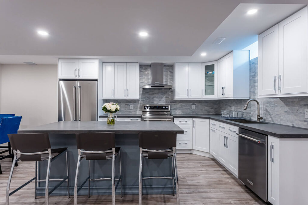 large kitchen renovation with centre island with chairs and white cabinets and countertop