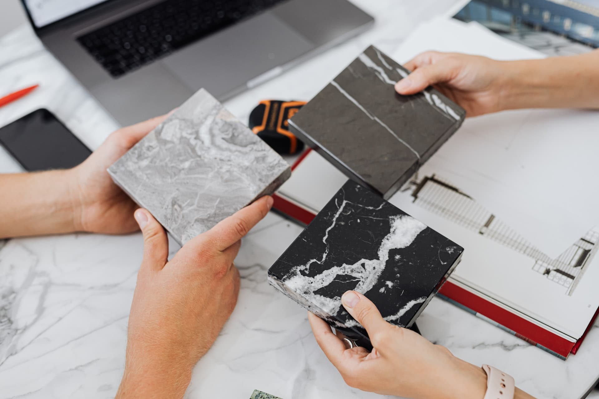 Stone countertop samples being compared by hand during material selection