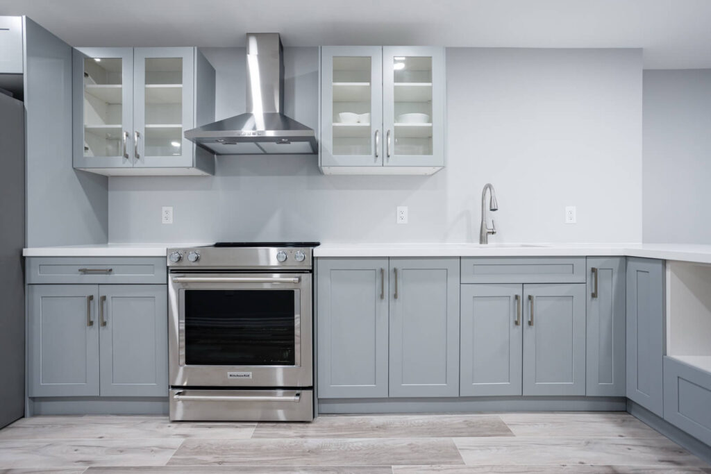 custom grey cabinets with glass door and cooktop
