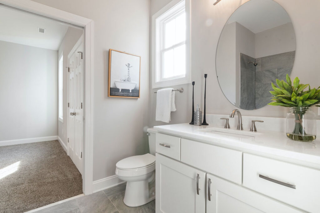 Powder room renovation in Toronto with modern vanity and window light Modern white powder room renovation with sleek vanity and natural light
