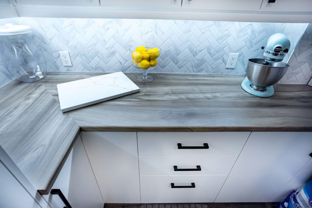 wooden countertop with white cabinets with drawer