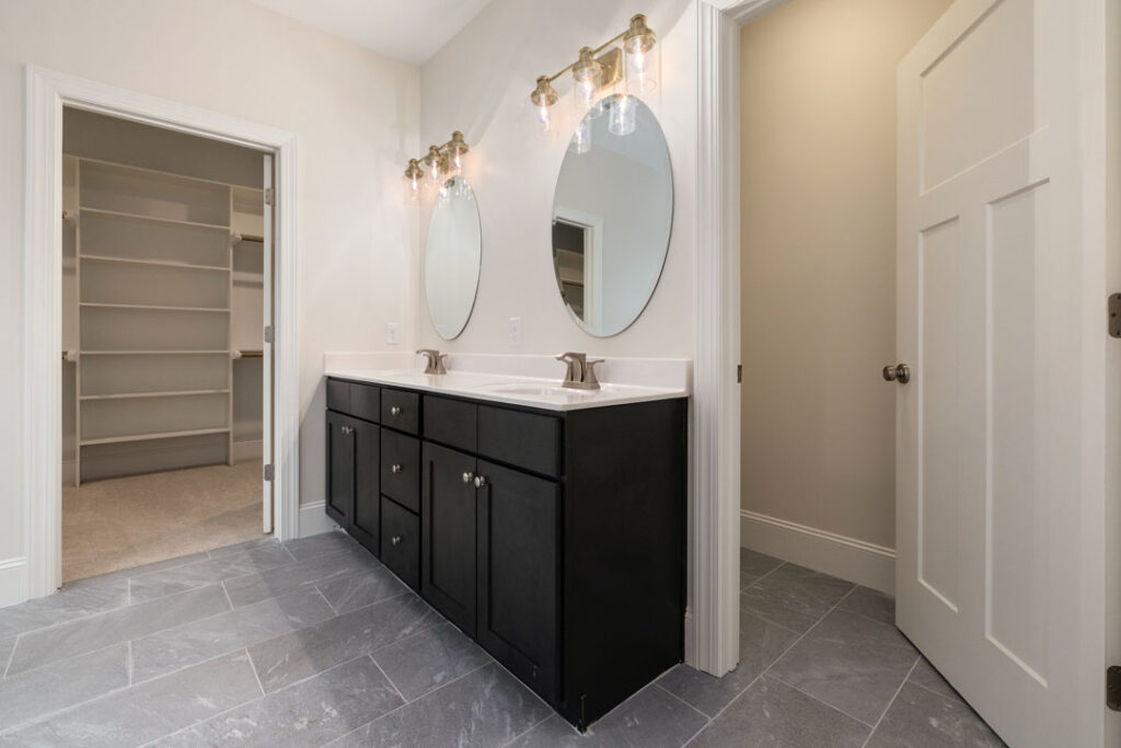 Contemporary powder room renovation in the GTA with dark cabinetry Elegant powder room renovation featuring black vanity and overhead lighting