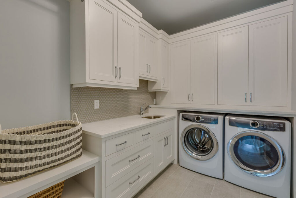 Laundry room remodeling project with custom cabinetry and tile backsplash laundry room remodeling with built-in cabinets, mosaic backsplash, and under-mount sink