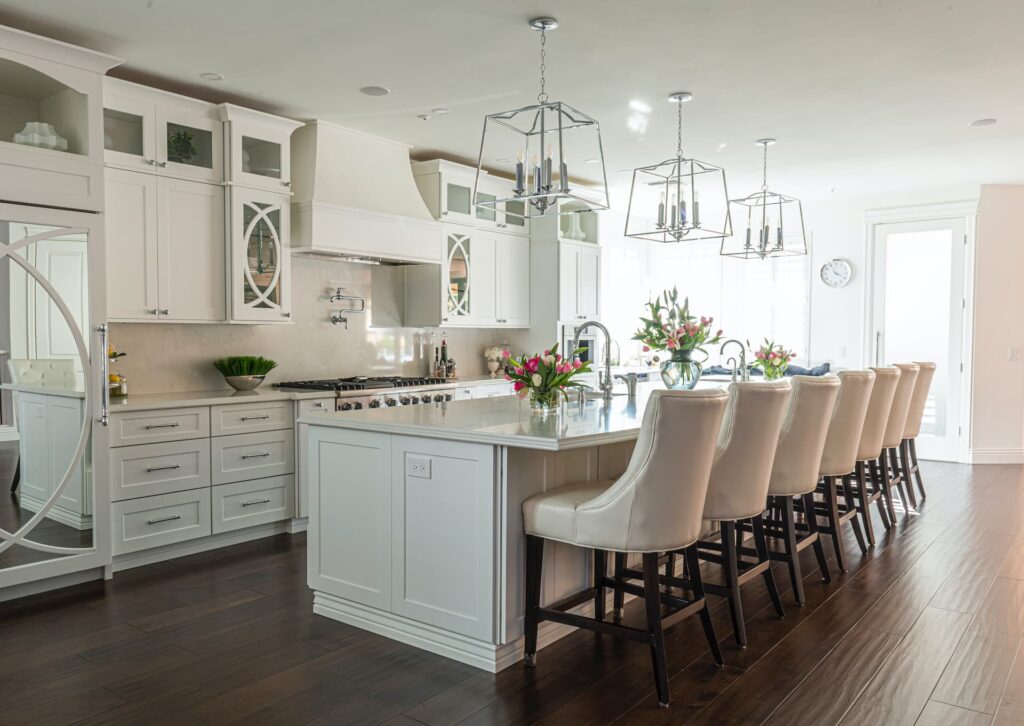 traditional white large kitchen island with chairs and custom cabinets and countertop