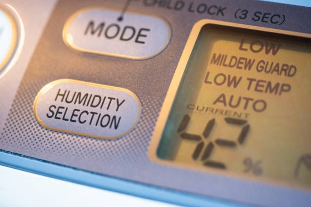Humidity setting control panel on a basement dehumidifier Digital basement dehumidifier set to 42% humidity