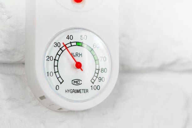 Basement humidity reading on a wall-mounted analog hygrometer Analog hygrometer showing basement humidity level